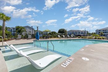 Resort style swimming pool is next to our building with apartment buildings in the background at The Parker Myrtle Beach, Myrtle Beach